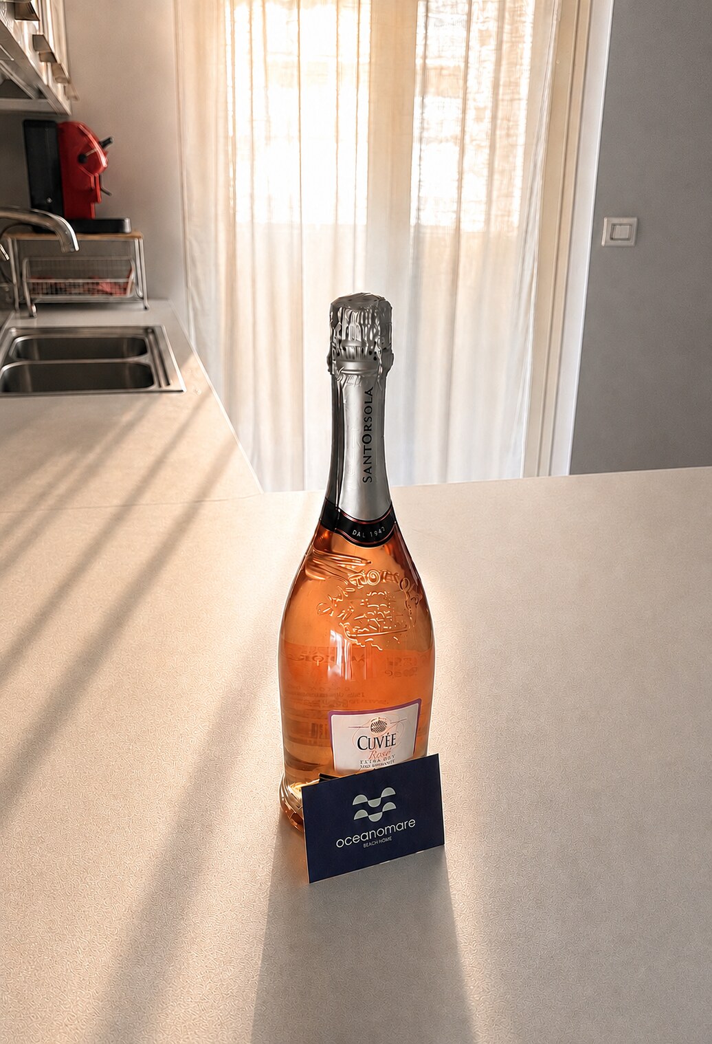 Italian rosé sparkling wine and Oceanomare welcome card in the apartment